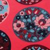 Närbild på röd jogging med mönster av blommor i cirklar i blått, rosa och vinrött, från artikeln Rävblomma Röd – Mönstrad Jogging.