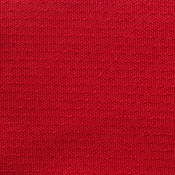 N&auml;rbild p&aring; r&ouml;d strukturstickad trik&aring; i 100% polyester, 160 cm bred.
